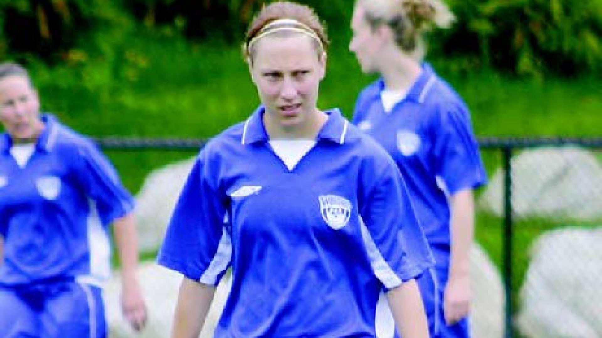 Sadie McLure walks down the field dressed in her blue uniform.